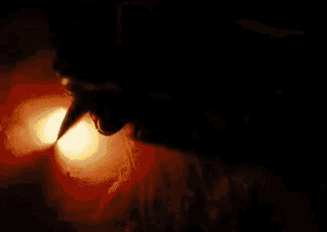 Animated meme of a dark silhouetted figure lit by a glowing orange flame