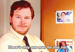 Man in a shirt and tie nodding at the camera with the subtitle 'There's only one man for this job'